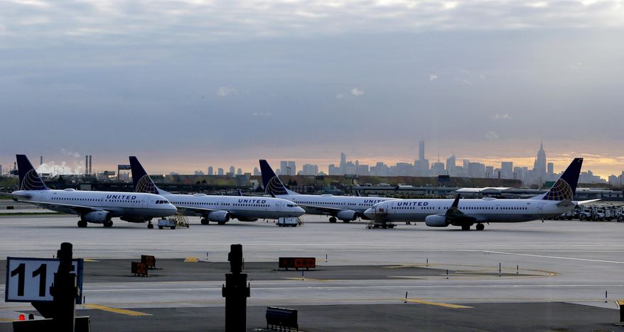 In this May 1, 2015 photo, United Airlines jets are parked at Newark Liberty International Airport as the sun rises behind the New York City skyline, in Newark, N.J. United Airlines on Tuesday, June 16, 2015 said it will stop flying to New York's Kennedy Airport in October and shift the remaining cross-country flights there to its nearby hub in Newark. (AP Photo/Julio Cortez)