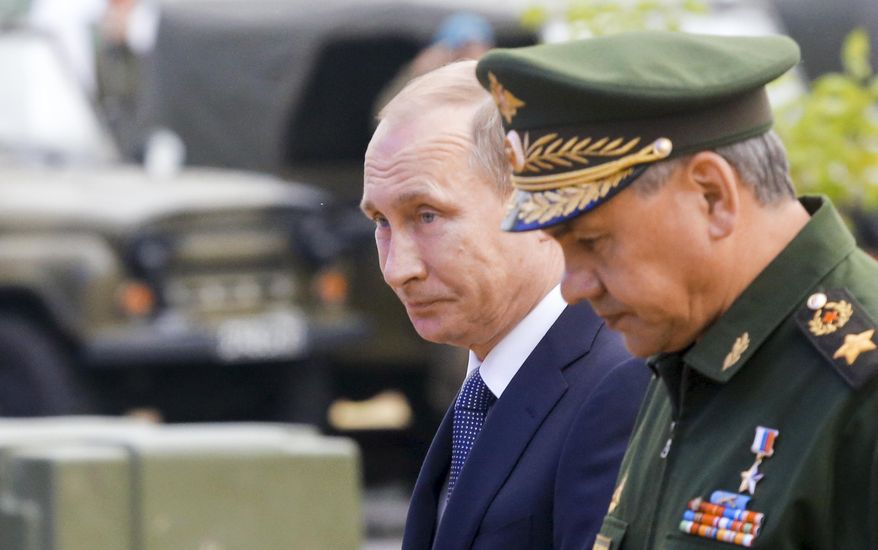 Russian President Vladimir Putin, left, and Defense Minister Sergei Shoigu, right, arrive to attend the opening of the Army-2015 international military show featuring the latest Russian weapons in Kubinka, outside Moscow, Russia, Tuesday, June 16, 2015. (Associated Press) ** FILE **