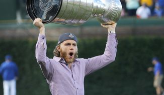 Chicago Blackhawks&#39; Patrick Kane carries the Stanley cup to the mound before an interleague baseball game between the Chicago Cubs and the Cleveland Indians Tuesday, June 16, 2015, in Chicago. (AP Photo/Charles Rex Arbogast)