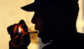 In this May 5, 2011, file photo an unidentified man smokes medical marijuana during karaoke night at the Cannabis Cafe, in Portland, Ore. (AP Photo/Rick Bowmer, File)