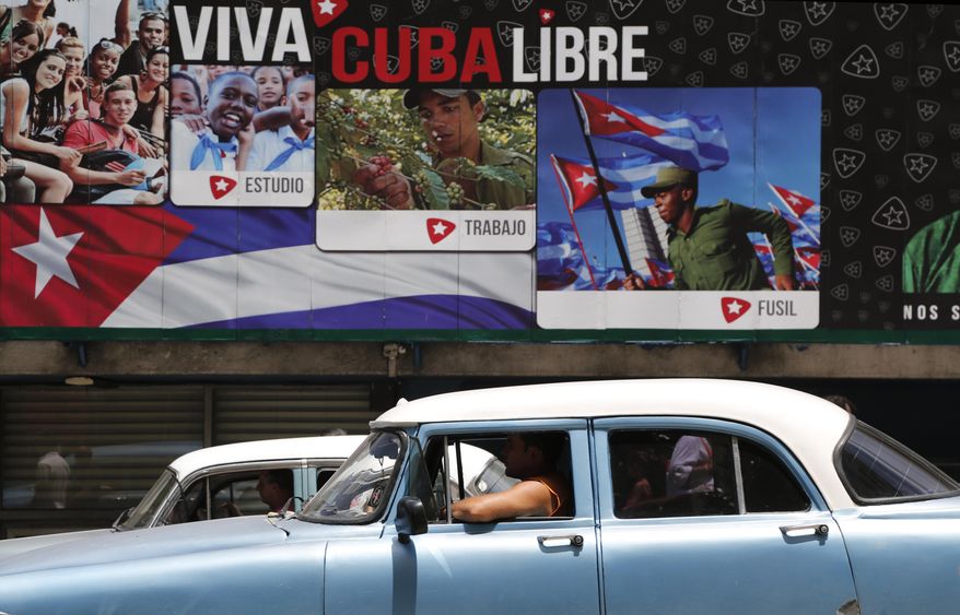 A classic American car passes in front of some signs that reads in Spanish &amp;quot;Long Live Free Cuba&amp;quot; in Havana, Cuba, Tuesday, June 16, 2015. Six months ago Wednesday, Presidents Barack Obama and Raul Castro stunned the world by announcing an end to their nations’ half-century of official hostility. In Cuba, aging leaders fear swift, uncontrolled change that would cost them power and spawn disorder in a country that dreads the violence and inequality scarring its neighbors. That fear is heightened by the United States’ long history of trying to topple Castro and his brother Fidel. (AP Photo/Desmond Boylan)