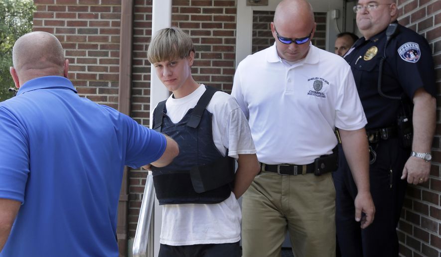 Charleston, S.C., shooting suspect Dylann Storm Roof, center, is escorted from the Shelby Police Department in Shelby, N.C., Thursday, June 18, 2015. Roof is a suspect in the shooting of several people Wednesday night at the historic The Emanuel African Methodist Episcopal Church in Charleston, S.C. (AP Photo/Chuck Burton) ** FILE **