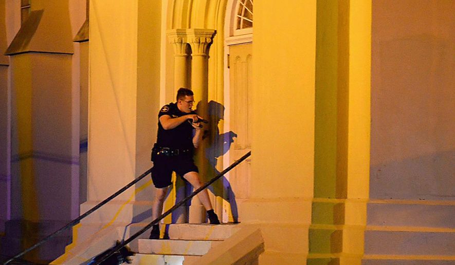 A police officer searches for a shooting suspect outside the Emanuel AME Church, in downtown Charleston, South Carolina on Wednesday. The shooting has prompted not just a calls for tighter gun-control laws, but also pleas from the right for churches to protect themselves by allowing their parishioners to carry concealed firearms. (Associated Press)