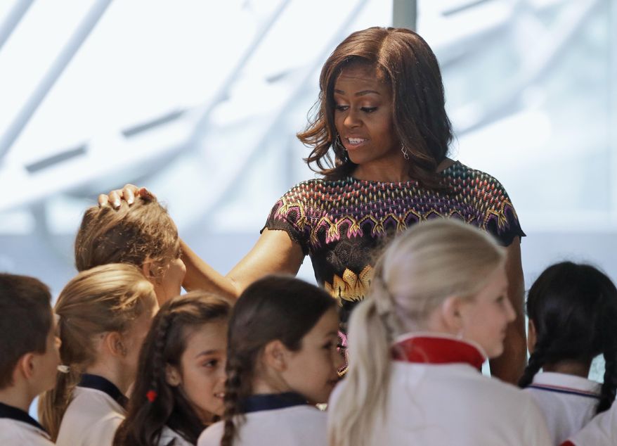 U.S. first lady Michelle Obama meets Italian schoolchildren during her visit at the Italian pavilion at the 2015 Expo in Rho, near Milan, Italy, Thursday, June 18, 2015. Mrs. Obama is leading a presidential delegation Thursday to the world's fair, organized around issues concerning food and nutrition, which dovetails with the U.S. first lady's "Let's Move" initiative to fight childhood obesity through diet and exercise. (AP Photo/Antonio Calanni)
