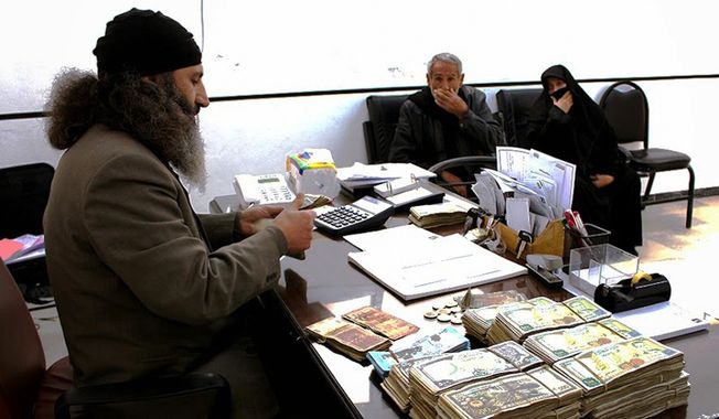 In this photo released on Feb. 10, 2015 by a militant website, which has been verified and is consistent with other AP reporting, two Syrian citizens, right, sit in the office of an inheritance judge of Islamic State group, in the town of al-Tabqa in Raqqa City, Syria. (Militant website via AP)