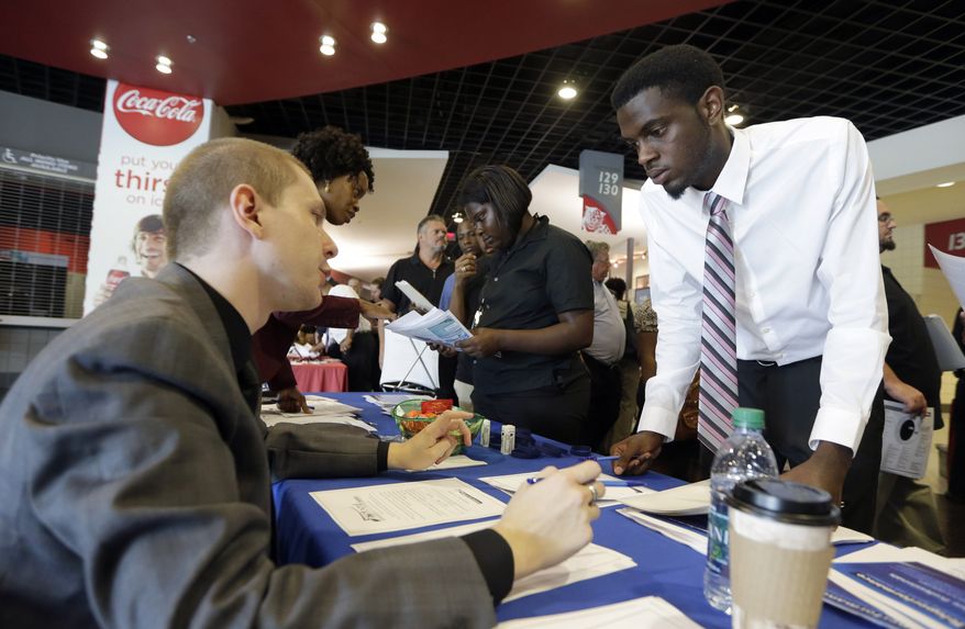 In this photo taken Wednesday, June 10, 2015, job seeker Cory McClain, right, listens to Sam Cucci, of Teleperformance, during a job fair in Sunrise, Fla. (AP Photo/Alan Diaz)