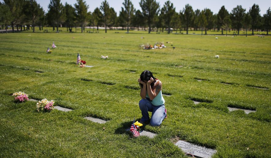 ADVANCE FOR USE SUNDAY, JUNE 21, 2014 AND THEREAFTER - In this June 10, 2015 photo, Rondha Gibson cries while visiting the grave of her husband, Stanley, in Boulder City, Nev. In December 2011, three years before many Americans began questioning police use of deadly force in the wake of incidents in Ferguson, Mo., Cleveland, New York and Baltimore, local leaders had just started acknowledging two decades of shootings by Las Vegas Metropolitan Police Department officers. But the killing of Stanley Gibson, cornered by police in a tan stucco apartment complex he apparently mistook for his own, was a flash point. (AP Photo/John Locher)