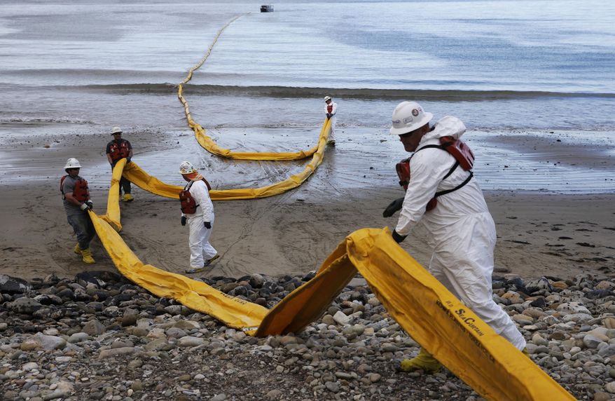 FILE - In this May 21, 2015 file photo, workers prepare an oil containment boom at Refugio State Beach, north of Goleta, Calif. Cleanup work continues one month after the May 19 oil spill north of Santa Barbara, Calif. The ruptured pipeline released up to 101,000 gallons of crude including 21,000 gallons that flowed into a storm drain and out into the Santa Barbara Channel.(AP Photo/Jae C. Hong, File)
