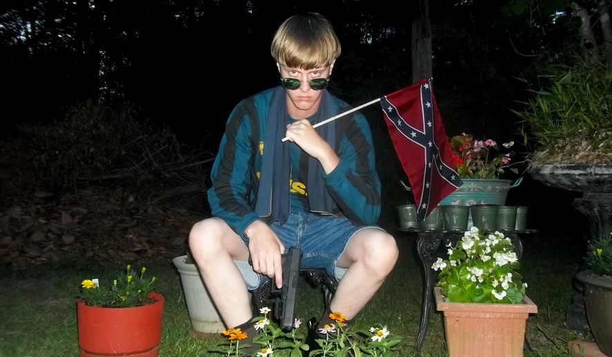 This undated image that appeared on Lastrhodesian.com, a website being investigated by the FBI in connection with Charleston, S.C., shooting suspect Dylann Roof, shows Roof posing for a photo while holding a Confederate flag. The website surfaced online Saturday, June 20, 2015, and also contained a hate-filled 2,500-word essay that talks about white supremacy and concludes by saying the author alone will need to take action. (Lastrhodesian.com via AP)