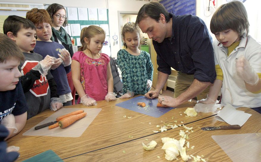 FILE - In this Feb. 3, 2010, file photo, teacher Keenan Haley, second from right, works with students at the Sharon Elementary School in Sharon, Vt. The school incorporates locally grown fruits and vegetables into the lunch menu. The state has made a name for itself getting more locally raised foods into school cafeterias, and curriculum about nutrition and agriculture into its classrooms. In 2015, Vermont will serve as a classroom of its own to 13 schools around the Northeast and others who want to learn more about the model and develop their own plans. The Northeast Farm to School Institute takes place at Shelburne Farms, funded by a $100,000 U.S. Department of Agriculture grant. (AP Photo/Toby Talbot, File)