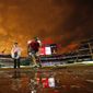 A member of the grounds crew works on the field as the sunset turns the sky a golden yellow during a rain delay before a baseball game between the Washington Nationals and the Atlanta Braves at Nationals Park, Tuesday, June 23, 2015, in Washington. (AP Photo/Alex Brandon)