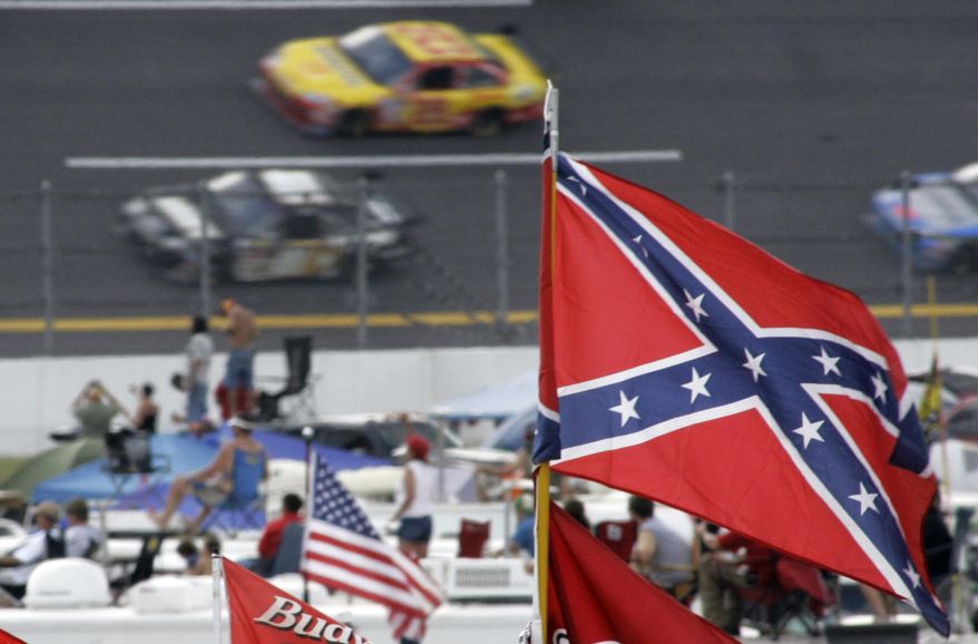 FILE - In this Oct. 7, 2007, file photo, a Confederate flags fly in the infield as cars come out of turn one during a NASCAR auto race at Talladega Superspeedway in Talladega, Ala. NASCAR is backing South Carolina Gov. Nikki Haley&#x27;s call to remove the Confederate flag from the South Carolina Statehouse grounds in the wake of a massacre at a Charleston church, it said in a statement Tuesday, June 23, 2015. Though NASCAR bars the use of the flag in any official capacity, many fans fly the flag at their races.  (AP Photo/Rob Carr, File)