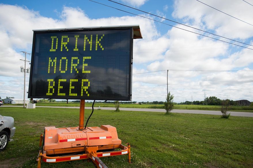 An electronic road sign with the words “DRINK MORE BEER” is shown on Tuesday, June 23, 2015, in Frankenlust Township, Mich. An auction company has sold the sign for about $600 after it attracted attention from passers-by with its message. (Yfat Yossifor/The Bay City Times via AP) LOCAL TELEVISION OUT; LOCAL INTERNET