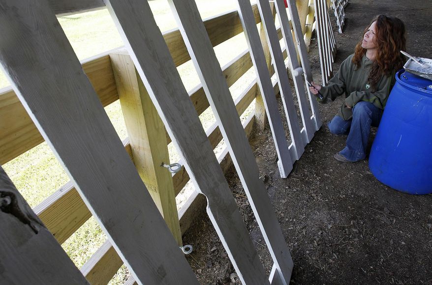 In this June 19, 2015 photo Tara Parks gives fences a fresh new coat of white paint as she tends to the grounds in preparation for the August fair at McHenry County Fairgrounds in Woodstock, Ill. The possible loss of state funding for county fair prizes and rehabilitation projects could affect county fair budgets across Illinois. Gov. Bruce Rauner listed those as part of his proposed cuts if the Republican and Democratic lawmakers don't agree on a budget deal starting July 1. (Matthew Apgar/Northwest Herald via AP) CHICAGO TRIBUNE OUT MANDATORY CREDIT