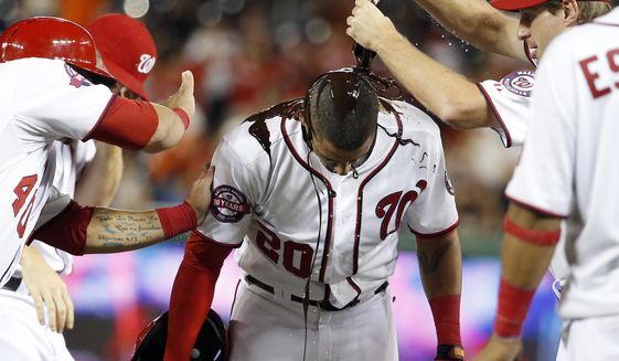 CORRECTS THAT DESMOND HIT SACRIFICE FLY, INSTEAD OF SINGLE - Washington Nationals&#x27; Ian Desmond is doused with chocolate syrup by Max Scherzer, right, after a baseball game against the Atlanta Braves at Nationals Park, Wednesday, June 24, 2015, in Washington. Desmond hit a sacrifice fly to score the winning run. The Nationals won 2-1 in 11 innings. (AP Photo/Alex Brandon)