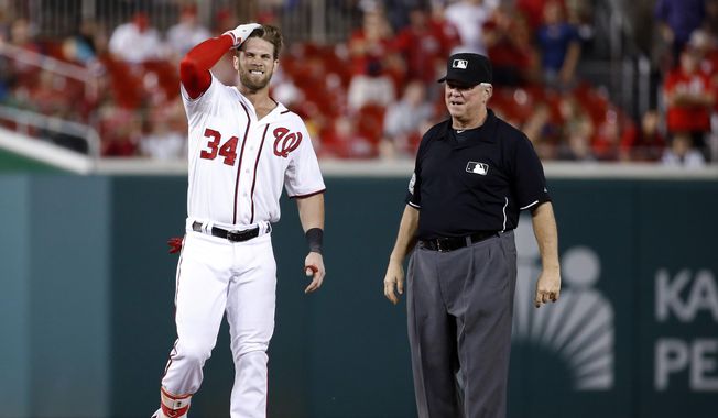 Washington Nationals&#x27; Bryce Harper grimaces after running to second base for a double during the 11th inning of a baseball game against the Atlanta Braves at Nationals Park, Wednesday, June 24, 2015, in Washington. Nationals manager Matt Williams and trainer Lee Kuntz checked on him, but he remained in the game. Harper later scored on a sacrifice fly by Ian Desmond. The Nationals won 2-1. (AP Photo/Alex Brandon)