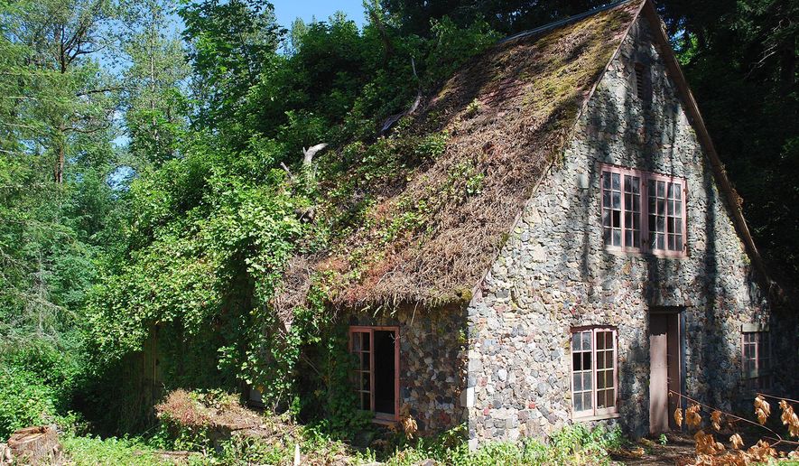 Hidden for decades behind a thicket of Douglas fir trees, this stone-covered cottage, built in 1923 near Lebanon, Ore., has been uncovered as dead trees have been removed from the property. (Alex Paul/Albany Democrat-Herald via AP)