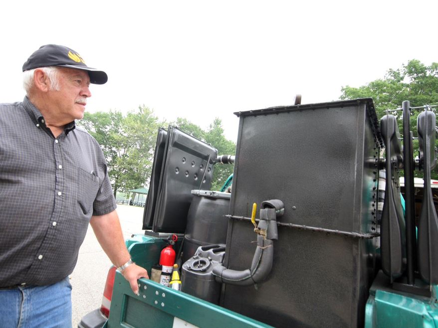In a June 2015, photo, Don Mannes looks over his wood burning stove that powers his 1995 Geo Tracker sport-utility vehicle in Zeeland Township, Mich. Instead of measuring miles per gallon like most motorists, Mannes measures mileage by miles per pound of wood burned. Two miles per pound of wood burned on average, Mannes said. Mannes can run his small green sport-utility vehicle by using nothing but carbon monoxide and hydrogen gas created by burning wood in a specially modified assembly on the back of vehicle. (Rob Wetterholt Jr./Holland Sentinel via AP)