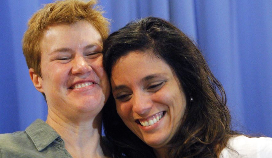 Val Tanco, right, and Sophie Jesty, plaintiffs in the Supreme Court case on gay marriage, smile during a news conference in Knoxville, Tenn. on Friday, June 26, 2015. Friday's Supreme Court ruling legalizes gay marriage nationwide, including in the 14 remaining states with bans. They moved to Tennessee for work after marrying in New York. (AP Photo/Wade Payne)