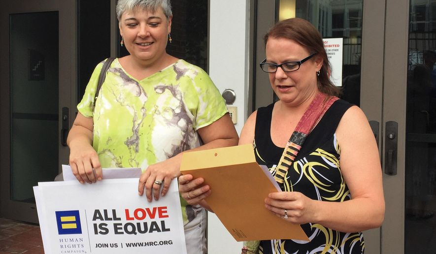 Newlyweds Jessica Dent, left, and Carolee Taylor leave a court building in Montgomery, Ala., with their wedding license on Friday, June 26, 2015. The two women were among the first same-sex couples to wed in Alabama after the U.S. Supreme Court ruled gay people can marry anywhere. (AP Photo/Kim Chandler)