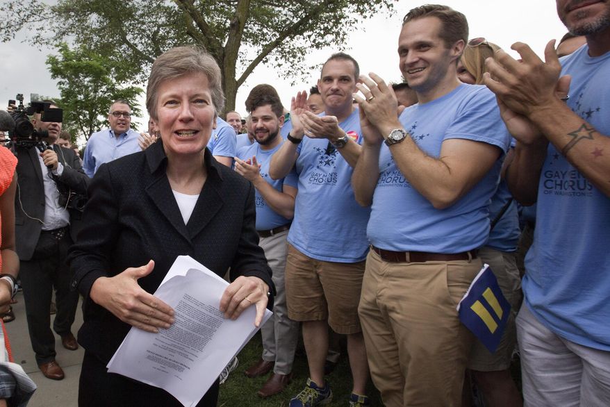Attorney Mary Bonauto, left, is applauded by the Gay Men's Chorus of Washington in Washington, Friday, June 26, 2015, after the Supreme Court declared that same-sex couples have a right to marry anywhere in the US. (AP Photo/Jacquelyn Martin)