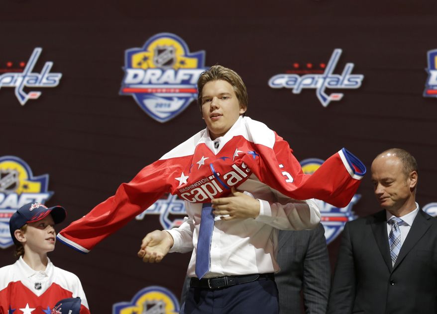  Ilya Samsonov, center, of Russia, puts on a Washington Capitals sweater after being chosen 22nd overall during the first round of the NHL hockey draft, Friday, June 26, 2015, in Sunrise, Fla. (AP Photo/Alan Diaz)