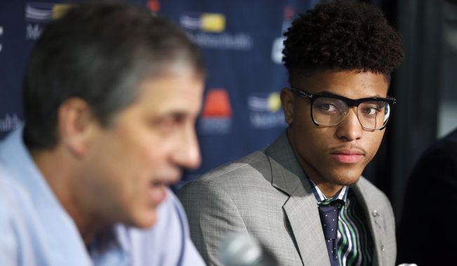 Washington Wizards&#x27; Kelly Oubre Jr., right listens to coach Randy Wittman speak during an NBA basketball news conference, Friday, June 26, 2015, in Washington. Washington moved up four spots in the first round to get the Kansas freshman in a trade with the Atlanta Hawks, who selected Oubre with the 15th overall pick in the NBA draft the night before. (AP Photo/Alex Brandon)