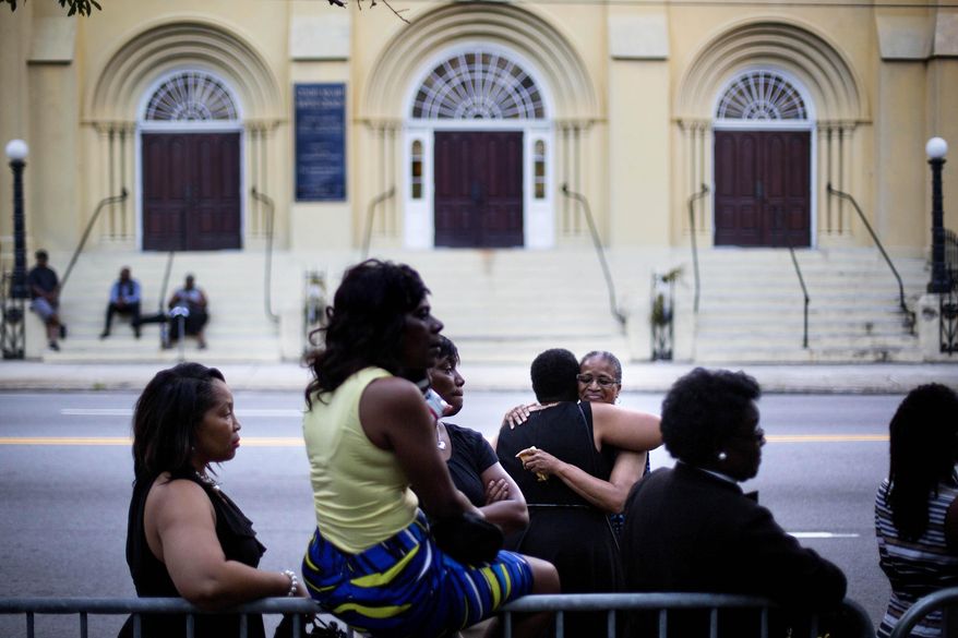 Lauretta Geddis, of Charelston, S.C., rear right, embraces Brenda T. Williams, of North Charelston, while waiting on line to enter Sen. Clementa Pinckney&#39;s funeral service, Friday, June 26, 2015, in Charleston. President Barack Obama delivered the eulogy at Pinckney&#39;s funeral Friday. (AP Photo/David Goldman)