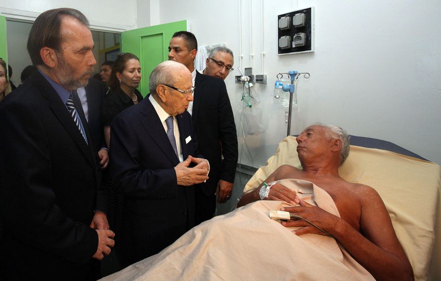 In this photo dated Friday, June 26, 2015, Tunisian President Beji Caid Essebsi, 2nd left, visits a survivor of a terrorist attack in an hospital in the costal town of Sousse, Tunisia. A young man pulled a Kalashnikov from a beach umbrella and sprayed gunfire at European sunbathers at a Tunisian resort, killing at least 39 people — one of three deadly attacks Friday from Europe to North Africa to the Middle East that followed a call to violence by Islamic State extremists. (Slim Abid/Tunisian Presidential Palace via AP)