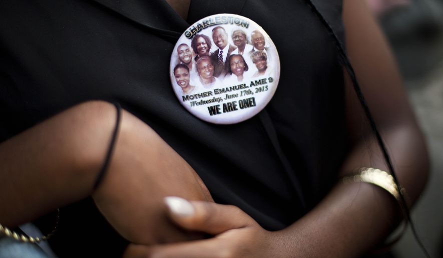 Krislynn Rambert, of Charleston, S.C., wears a button in memory of the victims of last week&#x27;s mass shooting while waiting on line to enter Sen. Clementa Pinckney&#x27;s funeral service, Friday, June 26, 2015, in Charleston, S.C. President Barack Obama will deliver the eulogy at Pinckney&#x27;s funeral at a nearby college arena. (AP Photo/David Goldman)