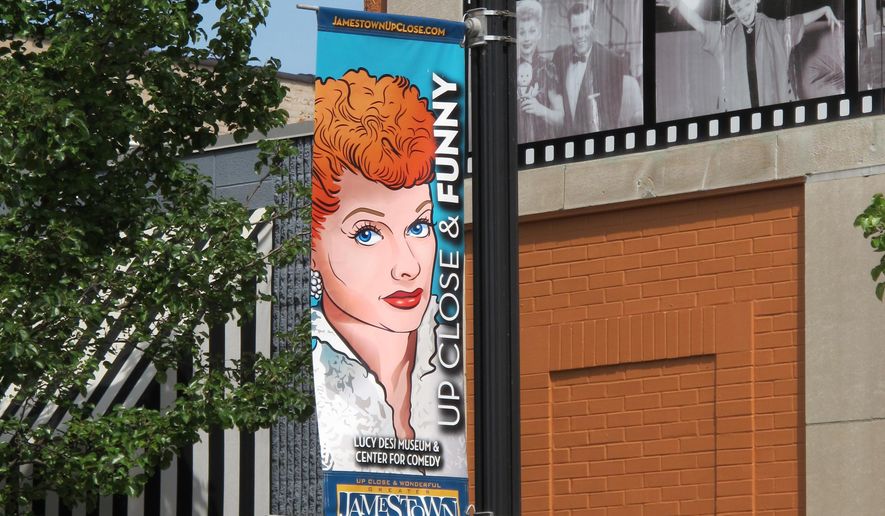 In this June 26, 2015 photo, a banner hangs outside the Lucille Ball-Desi Arnaz Museum in Ball's hometown of Jamestown, N.Y. The nonprofit National Comedy Center Inc., which runs the museum, plans to break ground this summer on the National Comedy Center to be located nearby. The national center will explore the art and science of comedy across all platforms and generations. (AP Photo/Carolyn Thompson)