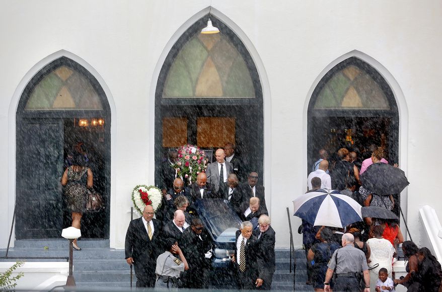Rain falls as pallbearers exit Emanuel AME Church carrying the casket of Cynthia Hurd as mourners for Susie Jackson and Tywanza Sanders file inside the church for their funerals Saturday, June 27, 2015, in Charleston, S.C. Hurd, Jackson and Sanders were three of the nine people killed in the shooting at the church on June 17. (Grace Beahm/The Post And Courier via AP) ** FILE **