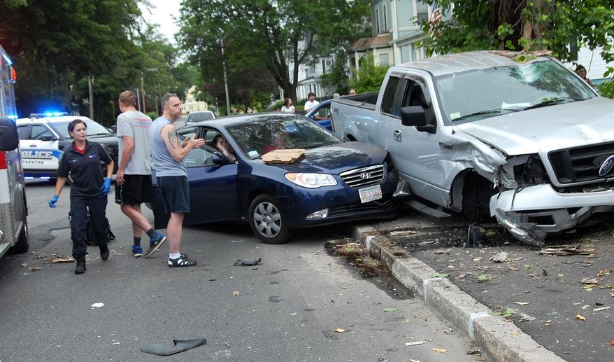 In this Saturday, June 27, 2015, photo, two women in a sedan await assistance after a pickup truck struck them in Tauton, Mass. Authorities say one person has died and others are injured after a Saturday afternoon shooting in Taunton. The Taunton Daily Gazette reported a pickup truck whose driver later said two of his passengers had been shot crashed into a sedan on nearby Harrison Street. (Charles Winokoor/The Daily Gazette via AP)
