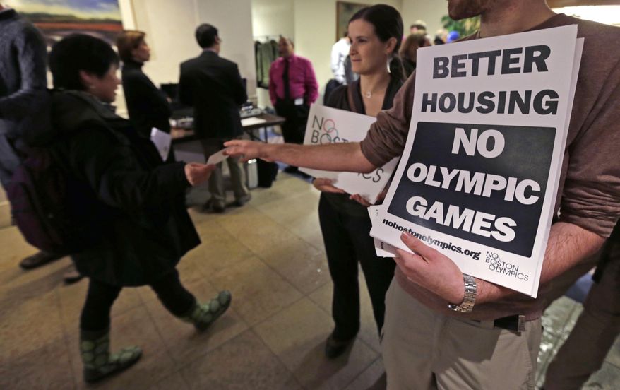 FILE - In this Feb. 5, 2015, file photo, Jonathan Cohn, of the Fenway neighborhood of Boston, hands out fliers while standing with Claire Blechman, of Somerville, Mass., prior to the first public forum regarding the Boston 2024 Olympic bid, in Boston. While Bostonians are hesitant to host the Olympics, Americans across the country overwhelmingly support the idea of the games on home turf, according to a new Associated Press-GfK poll. The support decreases when people are asked if they would want the Olympics in their local area. It dips even further when they are asked if public funds should be used to pay for them. (AP Photo/Charles Krupa, File)