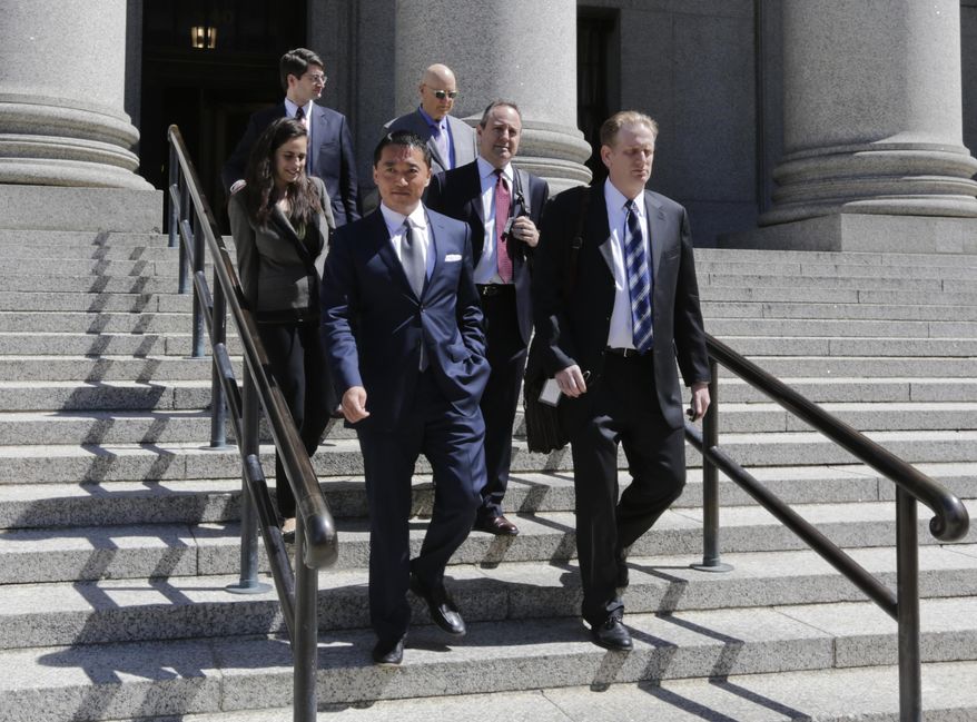 Benjamin Wey, CEO of New York Global Group, bottom left, leaves Manhattan Federal Court Wednesday, June 24, 2015, in New York. On Friday, June 26, a jury began deliberating in an $850 million lawsuit brought by a young woman who worked for Wey. Hanna Bouveng claims Benjamin Wey used his power as owner of New York Global Group to coerce her into four sexual encounters before firing her after discovering she had a boyfriend. She says he then launched a smear campaign through the Internet, depicting her falsely as a prostitute, extortionist or drug user, and wrote vicious emails to her friends and family. (AP Photo/Frank Franklin II)