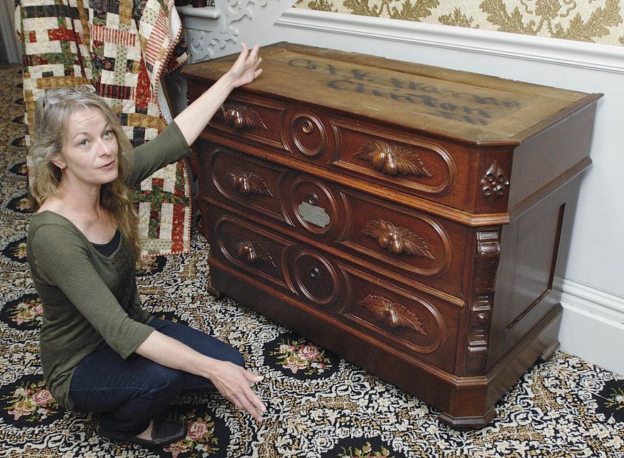 In this May 12, 2015 photo, Joey Woolridge, assistant manager at the C.H. Moore Homestead Museum in Clinton, Ill., explains her excitement about the recent donation to the museum of an 1860s-era dresser that was believed to be given as a wedding gift by the David Davis family of Bloomington to Vespasian and Winifred Moore Warner of Clinton. The dresser serves as an example of the strong bond between the Davises and the Moores, two of the wealthiest families in central Illinois at the time, and both with ties to Abraham Lincoln. The original marble top to the dresser is being restored. (Lori Ann Cook-Neisler/The Pantagraph via AP)