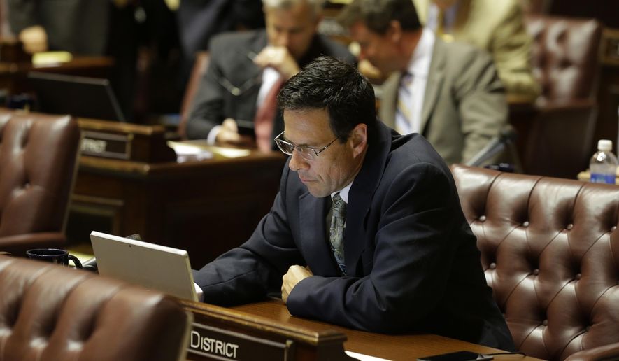 Sen. Andy Hill, R-Redmond, the Washington Senate's chief budget writer, works at his desk on the Senate floor, Tuesday, June 30, 2015, at the Capitol in Olympia, Wash. Washington Gov. Jay Inslee was expected to sign a two-year state operating budget later in the day that cuts tuition for college students and puts more money toward the state's K-12 education system. (AP Photo/Ted S. Warren)