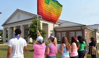 Protesters waive a rainbow flag on the front lawn of the Rowan County Judicial Center, Tuesday, June 30, 2015, in Morehead, Ky. The protest was being held against Rowan County Clerk Kim Davis, who, due to the ruling of the Supreme Court of the United States and her own religious beliefs, has refused to issue any marriage licenses in the county. (AP Photo/Timothy D. Easley)