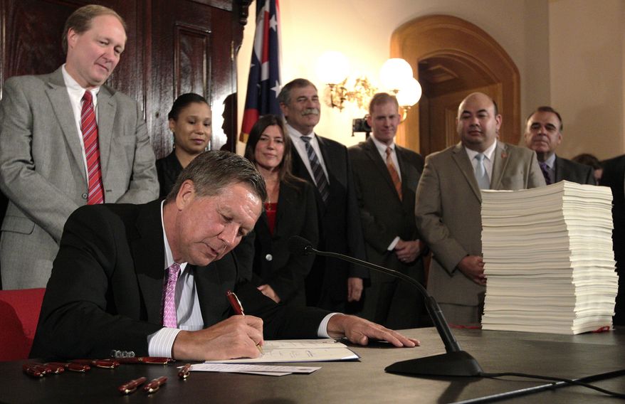Ohio Gov. John Kasich signs Ohio's 2016-2017 operating budget Tuesday, June 30, 2015, in Columbus, Ohio. Kasich said the $71.2 billion, 2-year state budget he signed helps people without getting "loose" with the spending. (AP Photo/Jay LaPrete)