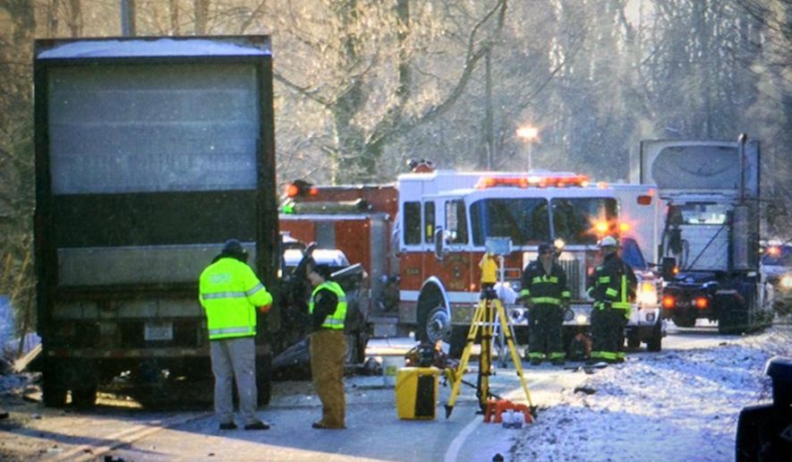 In this photo taken Jan. 24, 2014, crews investigate the scene of a double fatal crash involving a 12-ton semi-trailer loaded with groceries on U.S. 50, near state Route 222, in Stonelick Township, Ohio. At first the crash drew only the attention of Ohio authorities, who faulted the semi driver for not properly inspecting the hitch that holds the trailer to the tractor. But 17 months later, federal regulators are questioning whether a defective trailer hitch may be at fault, a hitch that’s currently used on about 6,000 semis. (Glenn Hartong/The Enquirer via AP) MANDATORY CREDIT; NO SALES