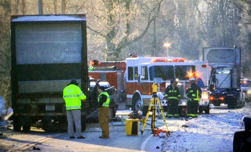 In this photo taken Jan. 24, 2014, crews investigate the scene of a double fatal crash involving a 12-ton semi-trailer loaded with groceries on U.S. 50, near state Route 222, in Stonelick Township, Ohio. At first the crash drew only the attention of Ohio authorities, who faulted the semi driver for not properly inspecting the hitch that holds the trailer to the tractor. But 17 months later, federal regulators are questioning whether a defective trailer hitch may be at fault, a hitch that’s currently used on about 6,000 semis. (Glenn Hartong/The Enquirer via AP) MANDATORY CREDIT; NO SALES