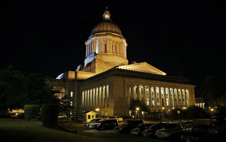 Vehicles remain parked outside the Legislative Building just after midnight, Wednesday, July 1, 2015, at the Capitol in Olympia, Wash., as Tuesday's legislative session continued into the night. Washington Gov. Jay Inslee signed the two-year state operating budget late Tuesday to avoid a government shutdown, but debate regarding the state transportation revenue package continued after midnight. (AP Photo/Ted S. Warren)