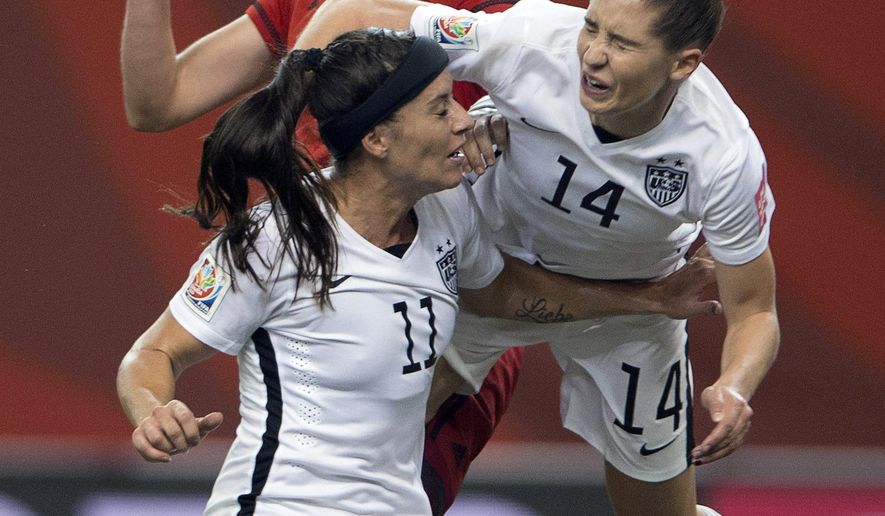 United States&#39; Morgan Brian (14) lands on teammate Ali Kreiger (11) after crashing into Germany&#39;s Alexandra Popp, back, during the first half of a semifinal in the Women&#39;s World Cup soccer tournament, Tuesday, June 30, 2015, in Montreal, Canada. (Ryan Remiorz/The Canadian Press via AP)