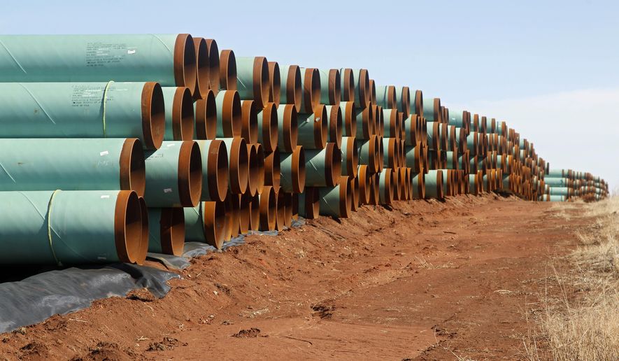 In this Feb. 1, 2012 file photo, miles of pipe for the stalled Canada-to-Texas Keystone XL pipeline are stacked in a field near Ripley, Okla. (AP Photo/Sue Ogrocki, File) — FILE 