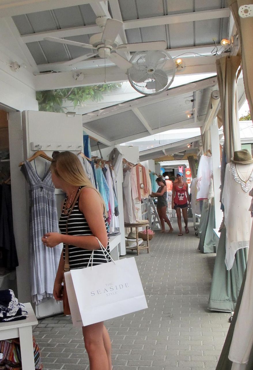 In this June 9, 2015 photo, a shopper peruses the open-air boutiques in Seaside, Fla. "Nashville South," a once quiet, isolated about 26-mile stretch of the Panhandle between Destin and Panama City that has transformed into a vacation capital for the South's rich and famous. (AP Melissa Nelson-Gabriel)