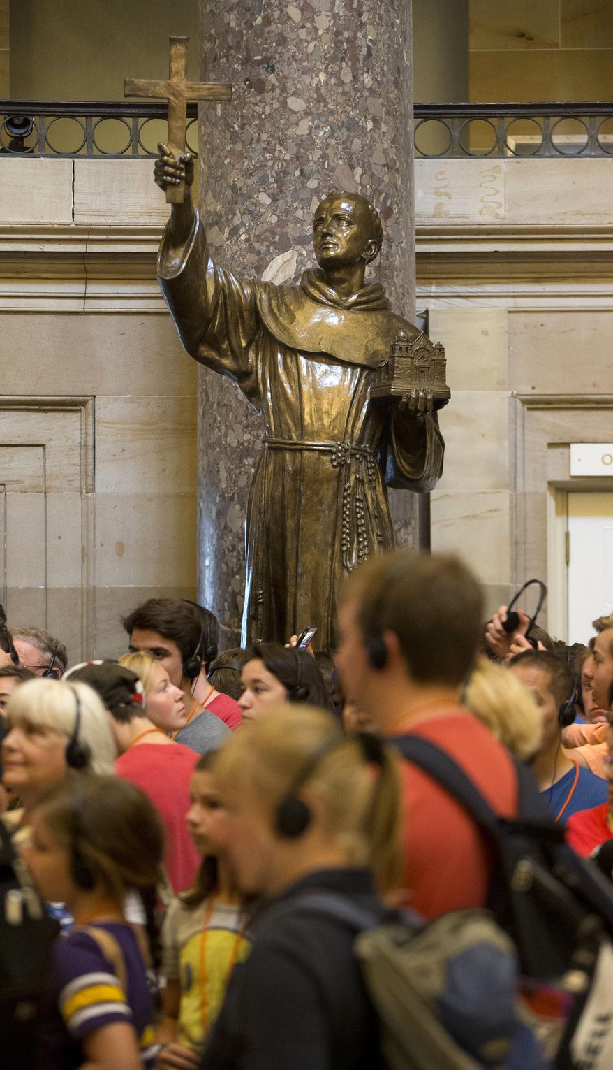 Capitol Hill visitors walk in front of a statue of missionary Junipero Serra, center, located in Statuary Hall, also known as the Old Hall of the House, on Capitol Hill in Washington, Thursday, July 2, 2015. California lawmakers are shelving a plan to replace the statue with late astronaut Sally Ride, bowing to pressure to drop the idea until after Pope Francis' September visit to the U.S., when he plans to make the 18th century missionary a saint. (AP Photo/Pablo Martinez Monsivais)