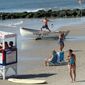 This Aug. 29, 2012 photo shows a lifeguard exercising atop a rowboat as people walk on the beach in Ocean City, N.J. Ocean City was named New Jersey&#39;s most popular beach on Thursday July 2, 2015, marking the second year in a row and third time overall that the southern New Jersey resort won an online voting competition. (AP Photo/Wayne Parry)