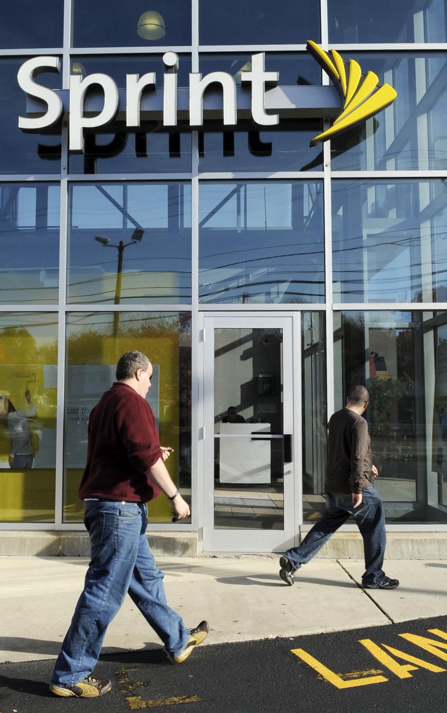 FILE - In this photo Oct. 26, 2009 file photo, customers enter a Sprint store in Saugus, Mass. Sprint is introducing an "all-in" pricing plan, meaning a single, $80-a-month price that includes both a smartphone and a service plan for voice, text and unlimited data. (AP Photo/Lisa Poole, File)