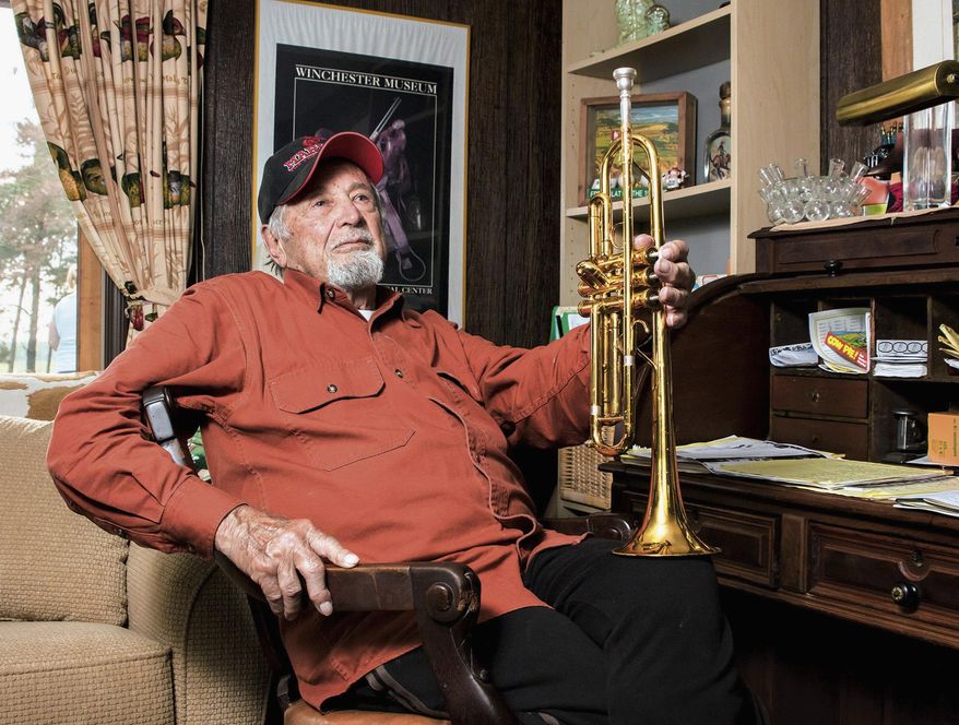 In this photo taken May 16, 2015, Ted Fredenhagen holds his trumpet as he poses for a photo at home in Amboy, Ill. Fredenhagen was bound for Iwo Jima as a Marine in 1945 when he was called back because he had been made a permanent member of the base band. Today, he still plays the trumpet, as part of local big band Class Act II. (Michael Krabbenhoeft/Sauk Valley Media via AP)