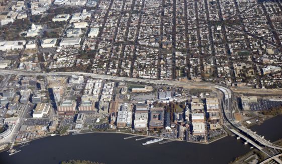 In this aerial photo taken Nov. 6, 2013, the Navy Yard Complex, along the Anacostia River, lower right. (AP Photo/Pablo Martinez Monsivais)